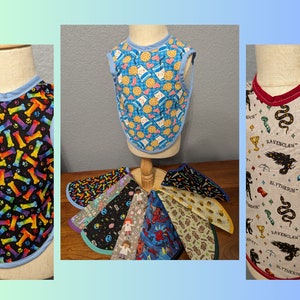 May include: A set of 10 colorful bibs with various patterns, including bones, cookies, and Harry Potter house crests. The bibs are made of fabric and have a blue or red trim.