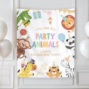 May include: A white banner with the text "Calling All Party Animals" and "Liam's Second Birthday" surrounded by cartoon animals and balloons. The banner is decorated with a giraffe, tiger, zebra, panda, lion, monkey, and alligator. White and tan balloons are in the foreground.