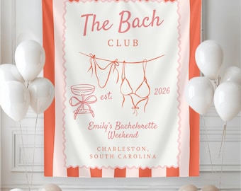 May include: A coral and white banner with the text "The Bach Club" and "Emily's Bachelorette Weekend" in a script font. The banner features illustrations of lingerie, a champagne glass, and the year 2026. White balloons are in the foreground.