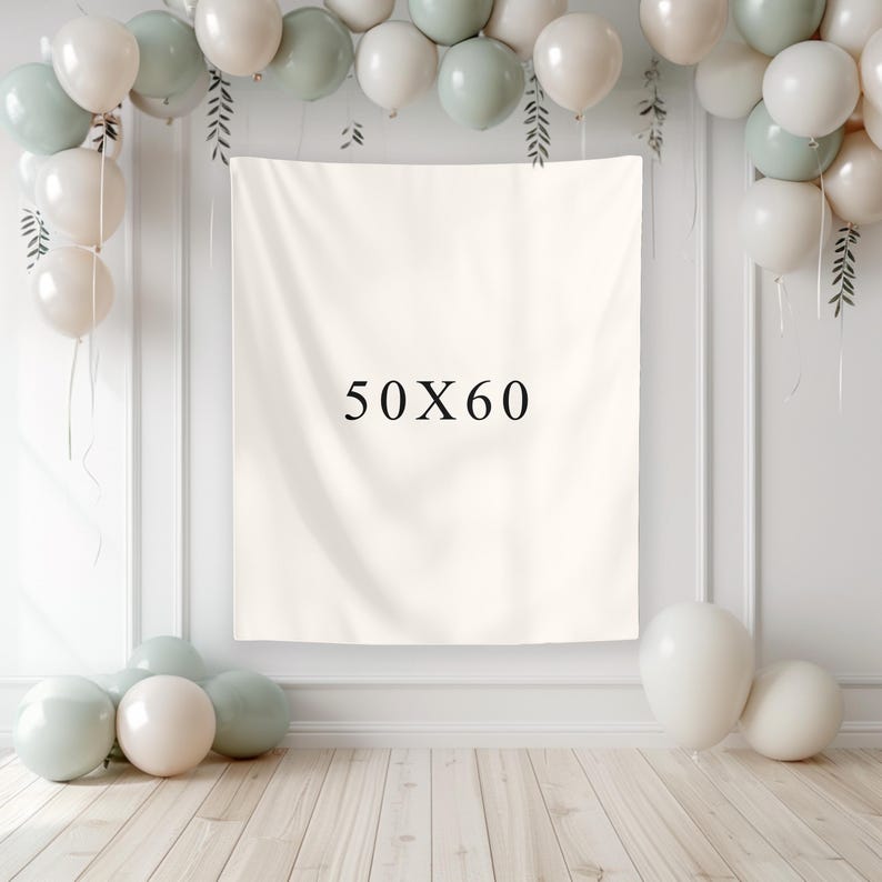 May include: A cream-colored backdrop with the text "50X60" is the focal point, surrounded by white, sage green, and cream-colored balloons. The backdrop is 50 inches by 60 inches. The balloons are arranged around the backdrop and on the floor, creating a festive atmosphere.