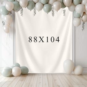 May include: A cream-colored backdrop with the text "88X104" in black, decorated with balloons in white and sage green. The balloons are arranged at the top and bottom of the backdrop, creating a festive atmosphere. The backdrop is likely used for events or photography.