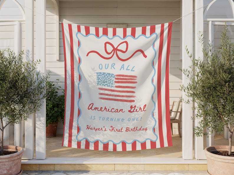 May include: A red and white striped banner with the text "OUR ALL American Girl is turning one! Harper's First Birthday" and a watercolor American flag design. The banner is hanging outside.