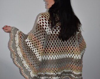 Peut inclure: Un poncho crocheté avec un motif multicolore dans les tons de brun, beige et blanc. Le poncho a une bordure festonnée et une coupe ample et fluide.
