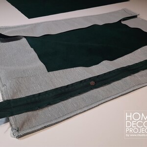 May include: A partially constructed dark green and gray fabric project. The project features a dark green zipper and a dark green fabric insert. The fabric is laid out on a white surface. The image includes the text "HOME DECOR PROJECTS by www.miusta.com.ar".