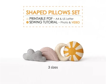 May include: A set of three shaped pillows: a gray cloud, a pink leaf, a cream-colored crescent moon, and a yellow and cream sun. The pillows are designed for a sewing tutorial, with printable PDF instructions available.