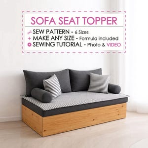 以下が含まれることがあります： グレーのクッションとストライプのシートトッパーが付いた木製のソファ。ソファには、2つのグレーの背もたれクッション、2つのストライプのクッション、2つの円筒形のボルスターがあります。壁のテキストは「SOFA SEAT TOPPER」と書かれています。