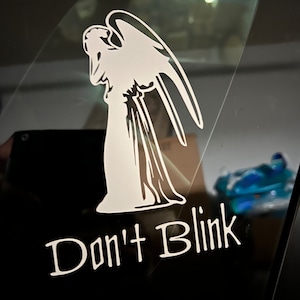 May include: A white vinyl sticker with a silhouette of an angel with wings and the text "Don't Blink".