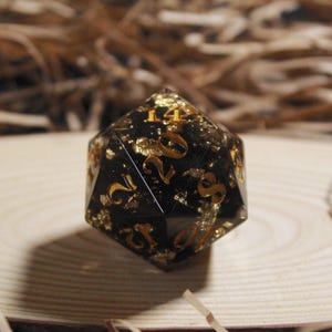 Elegante dado D20 negro y dorado de 35 mm