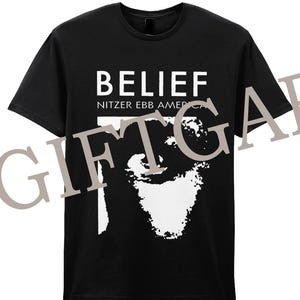 Könnte beinhalten: Schwarzes T-Shirt mit weißem Text, der "BELIEF" und "NITZER EBB AMERICA" lautet. Unter dem Text befindet sich eine weiße Grafik eines Gesichts.