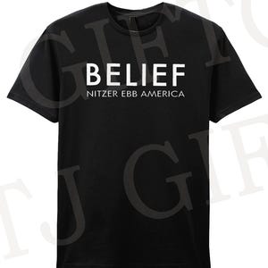 Könnte beinhalten: Schwarzes T-Shirt mit dem Wort "BELIEF" in großen weißen Buchstaben und dem Text "NITZER EBB AMERICA" darunter. Das T-Shirt hat kurze Ärmel und einen Rundhalsausschnitt.