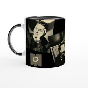 Puede incluir: Taza de café de cerámica blanca con interior y asa negros. La taza presenta un collage en blanco y negro de una persona con las letras "MD" en fuente gris. La taza está sobre un fondo blanco.