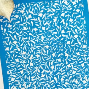 May include: A blue stencil with a white floral pattern. The stencil is labelled "TIDO CLAY TOOLS".
