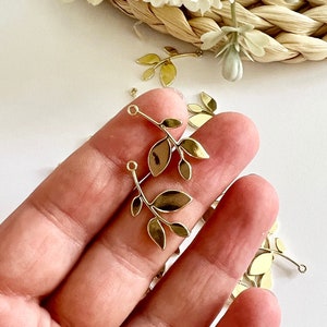 May include: Gold leaf branch charms with a loop at the top for attaching to jewelry or other crafts.
