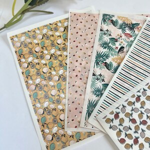 May include: Five sheets of decorative paper with different patterns. The patterns include lemons, polka dots, tropical leaves, stripes, and pineapples.