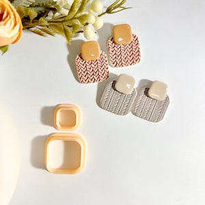 Könnte beinhalten: Vier Paar Ohrringe aus Polymer Clay mit einem Strickmuster. Zwei Paare sind rosa und beige, und zwei Paare sind grau und beige.