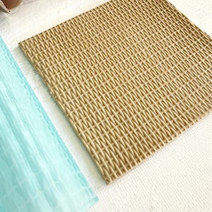 Peut inclure: Un moule en silicone brun clair avec un motif tissé. Le moule est conçu pour créer des décorations de gâteaux ou d'autres créations comestibles.