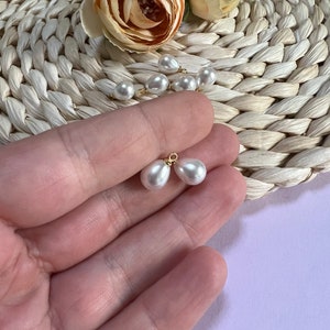 Puede incluir: Dos cuentas de perlas blancas con bucles dorados, perfectas para hacer joyas.