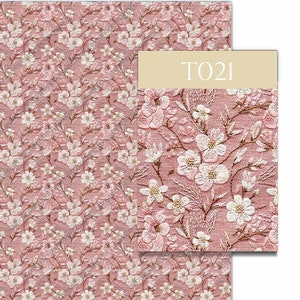 May include: A pink fabric with a white floral pattern. The fabric has a subtle texture and a repeating pattern of small white flowers on a pink background. The fabric is labeled "T021".