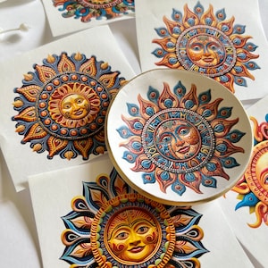 Puede incluir: Cinco pegatinas de mandala solar coloridas con detalles intrincados. Cada pegatina presenta un sol estilizado con una cara y una combinación de colores azul, naranja y amarillo.