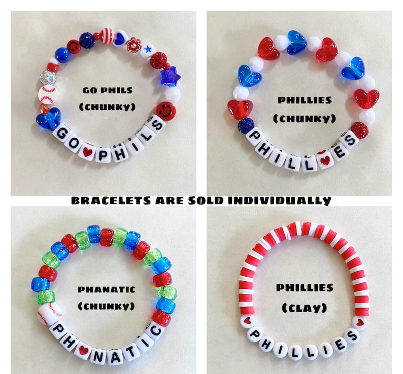 May include: Four beaded bracelets featuring red, white, and blue color schemes. Three bracelets use chunky plastic beads with letter cubes spelling GO PHILS, PHILLIES, and PHANATIC. One bracelet uses red and white clay discs spelling PHILLIES.