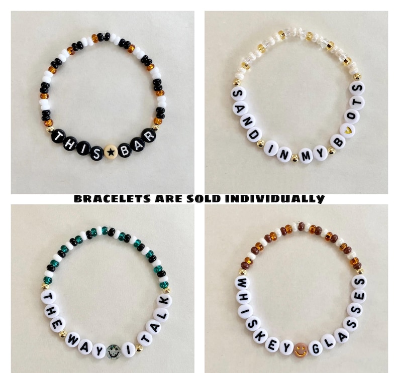 May include: Four beaded bracelets with different phrases. One bracelet says "THIS BAR" with a star bead. Another says "SAND IN MY BOOTS". The third says "THE WAY I TALK" with a smiley face bead. The last says "WHISKEY GLASSES" with a smiley face bead. Text on the image says "BRACELETS ARE SOLD INDIVIDUALLY".