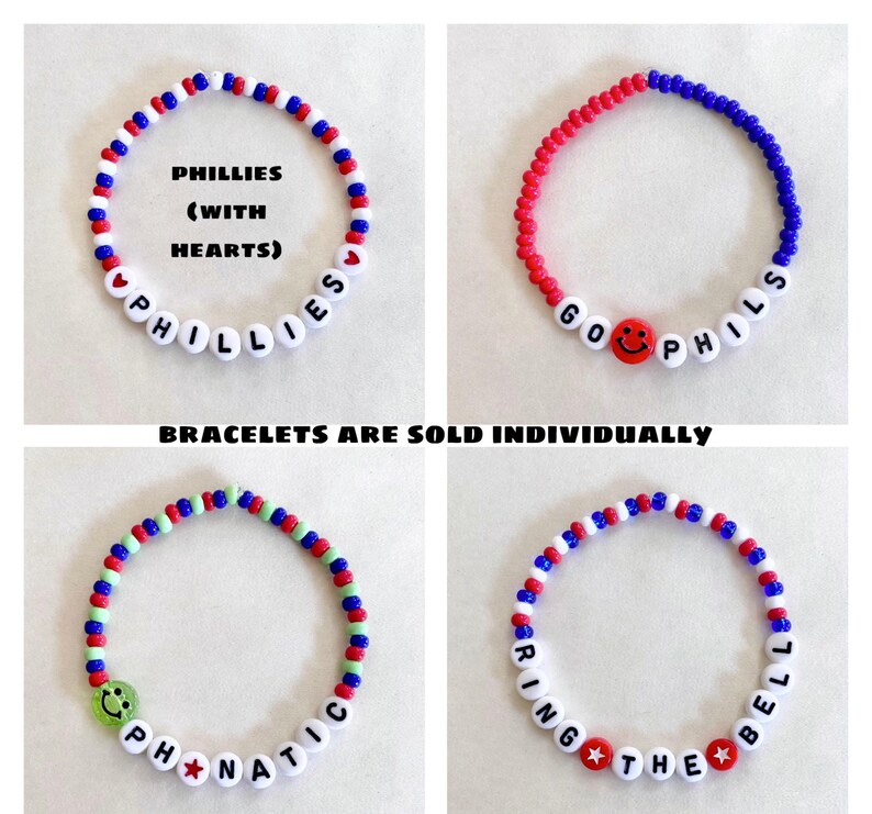 May include: Four beaded bracelets in red, white, blue, and green. Each bracelet features white letter beads spelling out phrases like "PHILLIES" and "RING THE BELL". Some bracelets include smiley face and star beads.