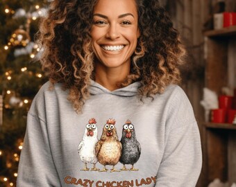 Könnte beinhalten: Ein grauer Kapuzenpullover mit einem Aufdruck von drei Cartoon-Hühnern und dem Text "Crazy Chicken Lady".