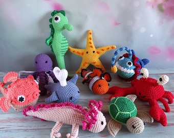 May include: A collection of crocheted sea creature toys, including a starfish, a seahorse, a clownfish, an octopus, a turtle, a sea monster, a crab, and an axolotl. The toys are all made with colorful yarn and have detailed features.