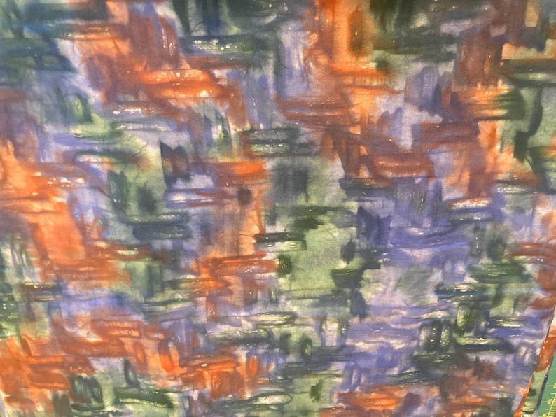 May include: Abstract watercolor fabric with a textured appearance. The design features overlapping brushstrokes in shades of orange, blue, green, and purple. The fabric has a slightly translucent quality, suggesting it may be a lightweight material.