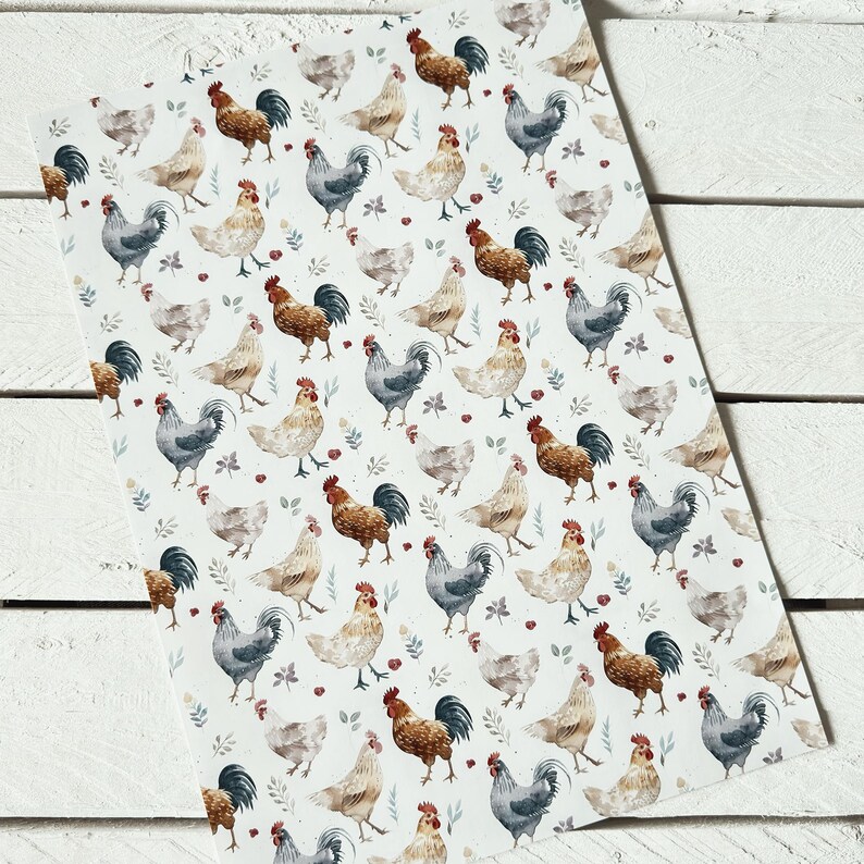 May include: A white fabric with a repeating pattern of watercolor roosters and hens. The roosters are brown, red, and gray, and the hens are white and gray. The background is white with small green leaves and red berries.