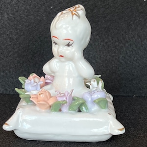 Vintage girl sitting on flower adorned pillow CWI