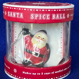 May include: A white ceramic Santa Claus spice ball in a red and white box. The box says "Santa Spice Ball" and "Makes up to 2 cups of mulled cider or tea".