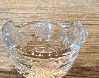 May include: A clear glass bowl with a decorative etched design. The bowl has a rounded shape and a slightly flared rim.