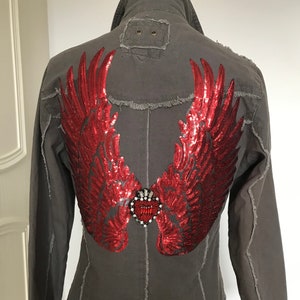May include: A grey denim jacket with red sequined wings and a jeweled heart on the back.