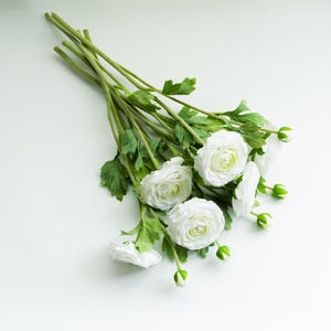 A white artificial buttercup with a realistic touch
