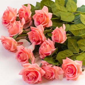 May include: A bouquet of pink roses with green leaves. The roses are arranged in a semi-circle shape.