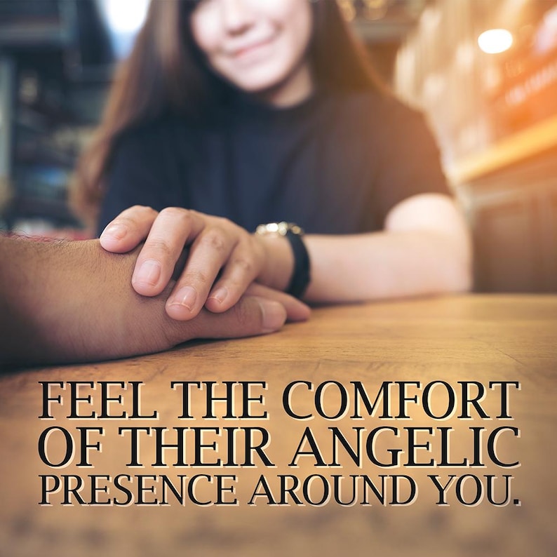 May include: Image of two hands clasped on a wooden table. The text reads: "FEEL THE COMFORT OF THEIR ANGELIC PRESENCE AROUND YOU." A person is in the background, out of focus.