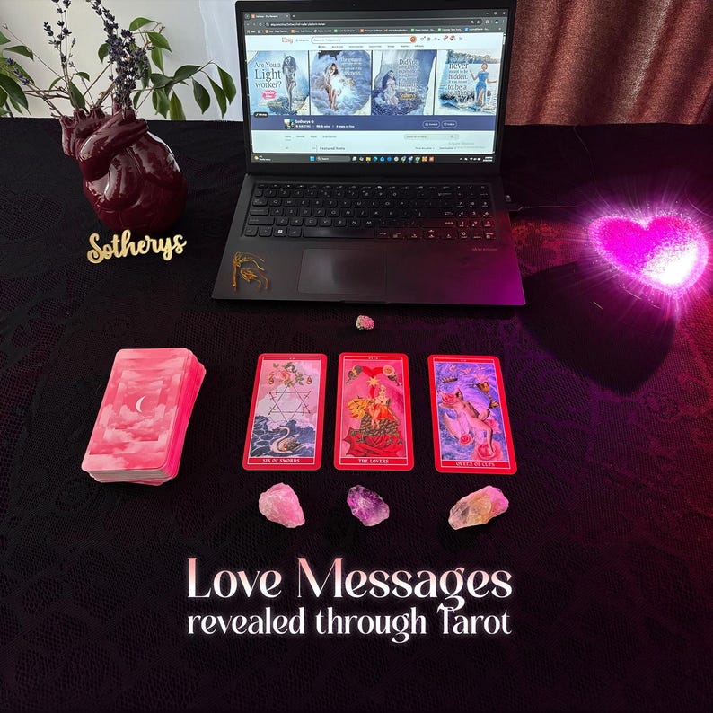 May include: A laptop displays book covers, with a stack of pink tarot cards and three face-up cards. The text "Love Messages revealed through Tarot" is at the bottom. Pink and clear crystals are scattered around the cards, with a heart-shaped vase and a glowing heart.