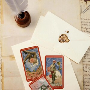 May include: An antique-style still life featuring tarot cards, envelopes with wax seals, and a quill pen in an inkwell. The tarot cards have red borders and feature illustrations. The envelopes are sealed with brown wax.