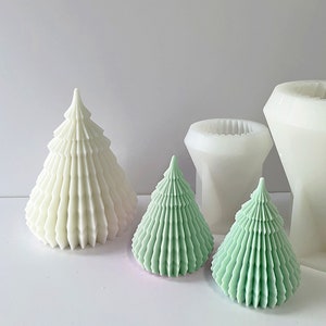 Puede incluir: Tres moldes para velas con forma de árbol de Navidad, dos son verdes y uno es blanco. Los moldes son de silicona y están diseñados para crear velas detalladas y texturizadas.