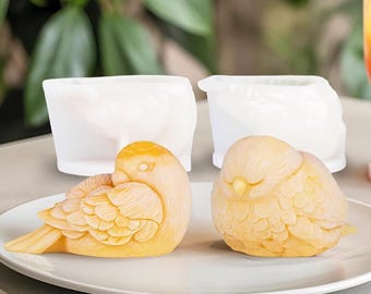 May include: Two yellow bird-shaped silicone molds on a white plate. The molds are detailed with feathers and have a realistic bird design.