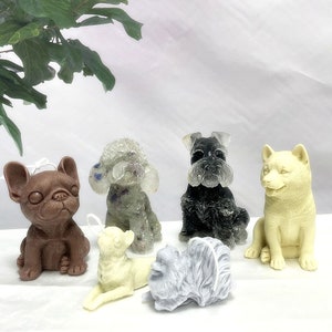 May include: Six different dog-shaped candles in various colors and poses. The candles are made of wax and have a realistic appearance. The candles are arranged on a white surface.