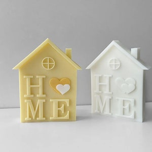 May include: Two decorative house-shaped figurines, one yellow and one white, both with the word "HOME" and a heart design.