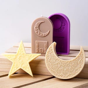 May include: Three candle molds for making Islamic-themed candles. The molds are made of silicone and are in the shapes of a crescent moon, a star, and a mosque. The crescent moon mold has a detailed mandala design.