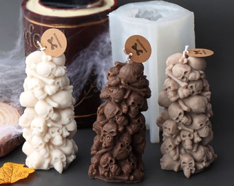 May include: Three white silicone molds for making skull-shaped candles. The molds are shaped like a stack of skulls and bones. The molds are labeled "Handmade".