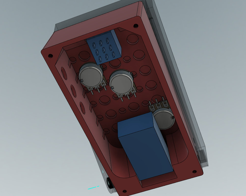 Op de afbeelding: Een rode rechthoekige behuizing voor elektronische componenten met verschillende ronde openingen. Binnenin bevinden zich drie zilveren potentiometers, een blauwe rechthoekige component en een blauwe component met zes gaten. De behuizing is aan de bovenkant open.