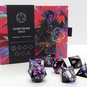 May include: A handmade 7-piece dice set with a box featuring a fantasy illustration. The dice are black with purple and green accents, and white numbering. The box has the text "EVERYTHING DICE" and "HANDMADE 7-PIECE DICE SET".