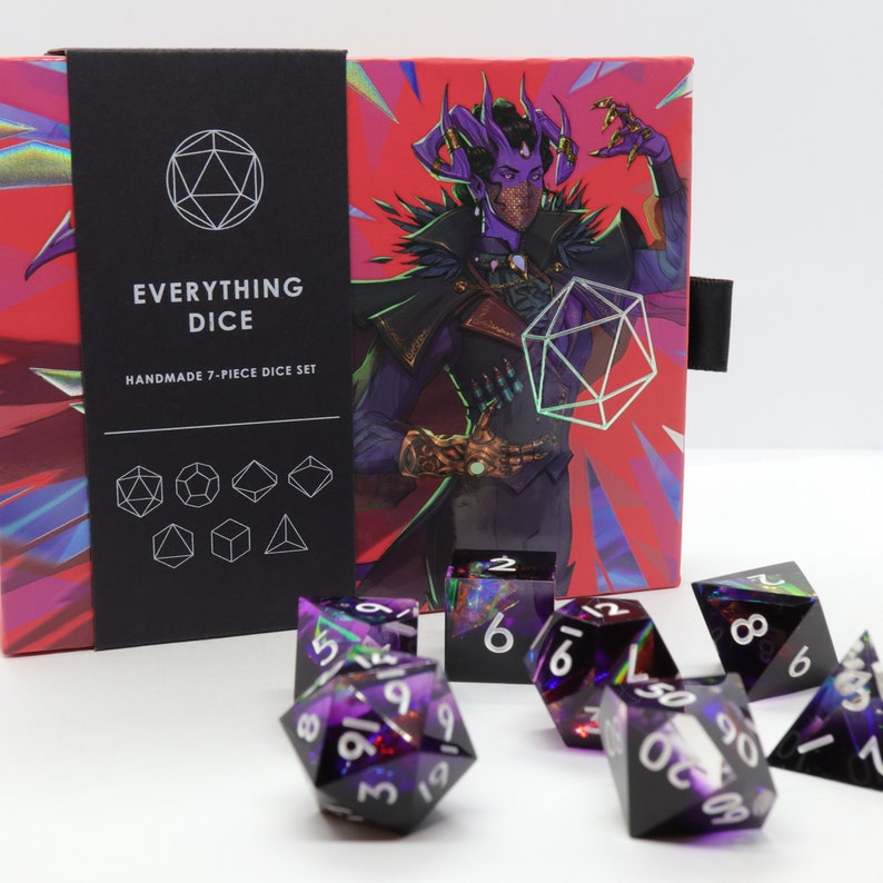 May include: A handmade 7-piece dice set with a box featuring a fantasy illustration. The dice are black with purple and green accents, and white numbering. The box has the text "EVERYTHING DICE" and "HANDMADE 7-PIECE DICE SET".