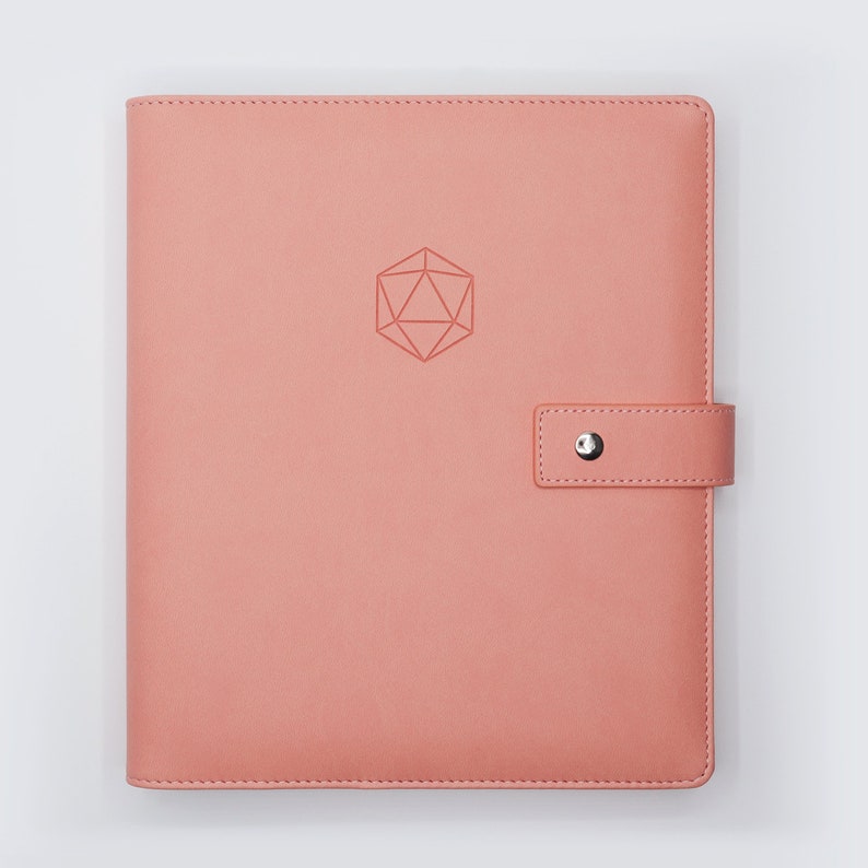 May include: A pink leather-bound journal with a geometric design embossed on the front cover. The journal has a silver clasp and a flap closure.