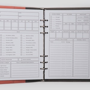 May include: A black and gray leather-bound notebook with a white interior. The notebook is open to a page with a character sheet for a role-playing game. The sheet includes sections for name, class, race, stats, skills, saving throws, hit points, death saves, attacks, and features and traits.